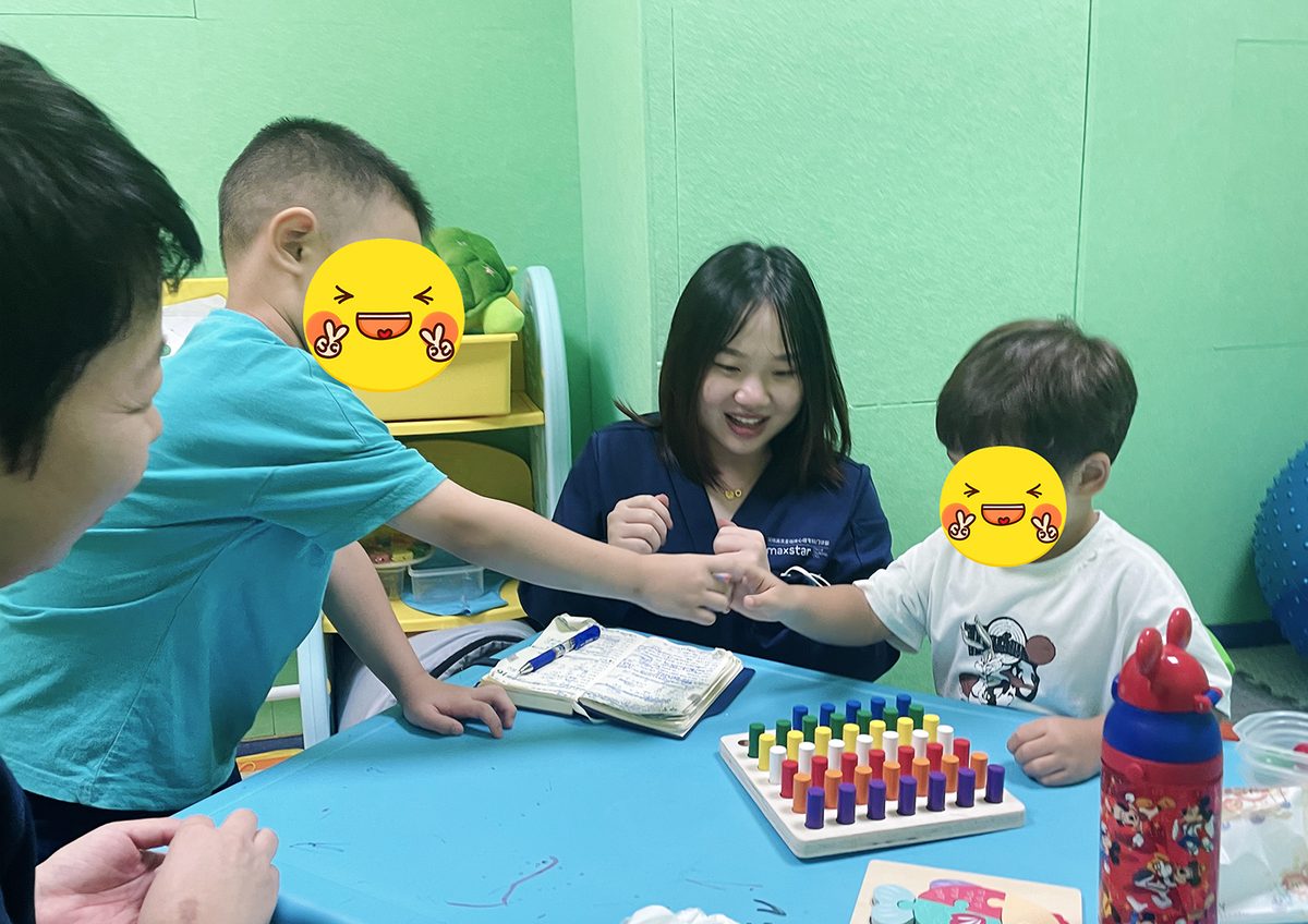 孩子与指导老师围桌进行拼插操作训练